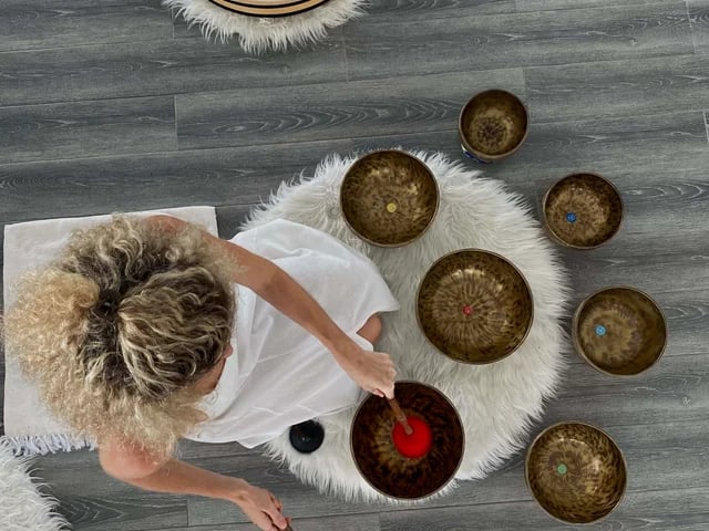 Overhead view of Tibetan singing bowls arranged in a circle during a sound healing session